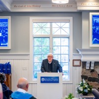 Man looking at crowd with Welcome Home Class of 1974 sign in the back